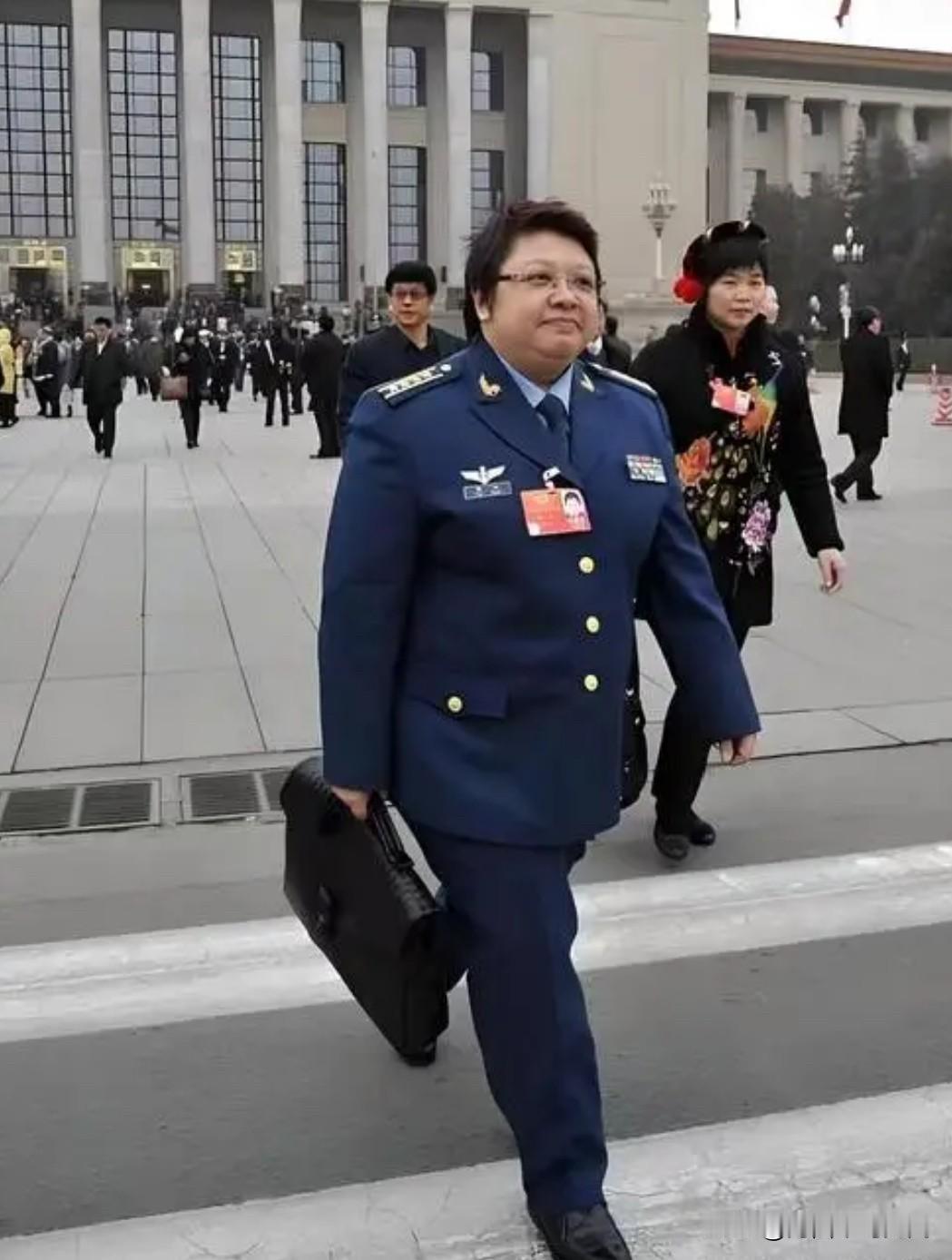 全国两会会场外，韩红身穿07式空军军官服，肩扛大校军衔，胸佩代表证，手提公文包，