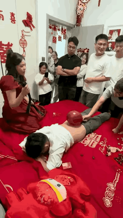一对新人大喜日子朋友们出小游戏，新娘用皮带打气球，但是朋友拿这个气球可以移动，新