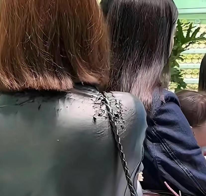 旁边那个小姐姐的皮衣，已经在掉渣了。坐近才发现，整块肩膀的涂层裂成碎屑，往下