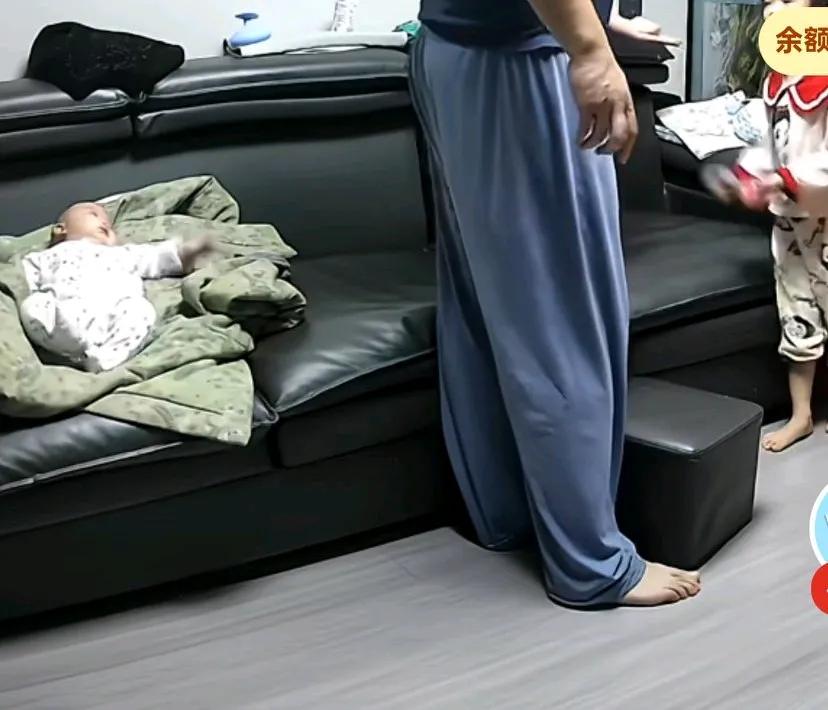把转身与大宝说话，结果身后的小宝自己翻身不慎从沙发上摔下来，爸爸吓得赶紧把小宝
