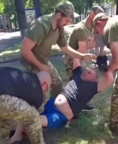 又一名乌克兰人被抬走。这是乌克兰征兵办人员上班的情景，虽然被征人员反抗激烈，