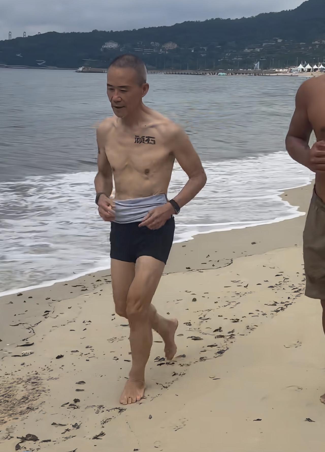 75岁王石在海边穿着泳裤跑步，上半身一点肌肉都没有，太瘦了肉都耷拉，还露出了纹身
