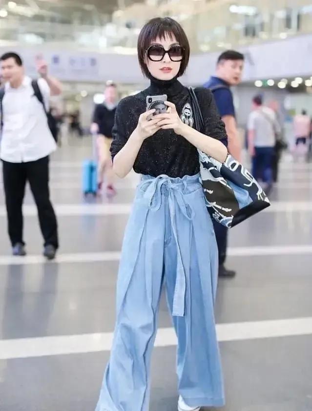 吴昕机场私服太会穿了！利落短发搭配黑高领打底，浅蓝花苞阔腿裤随性洒脱。上