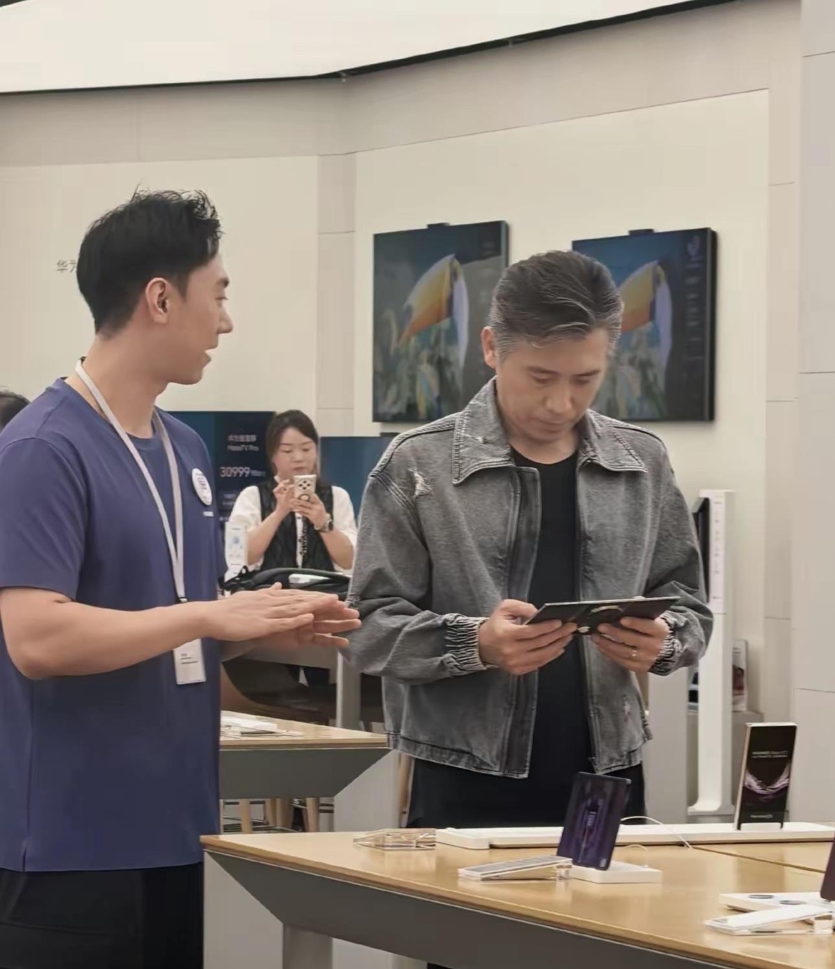 52岁的李乃文在重庆来福士华为门店试三折叠手机被路人拍到了，店员拿余承东那套物理防窥的梗给他讲解，左