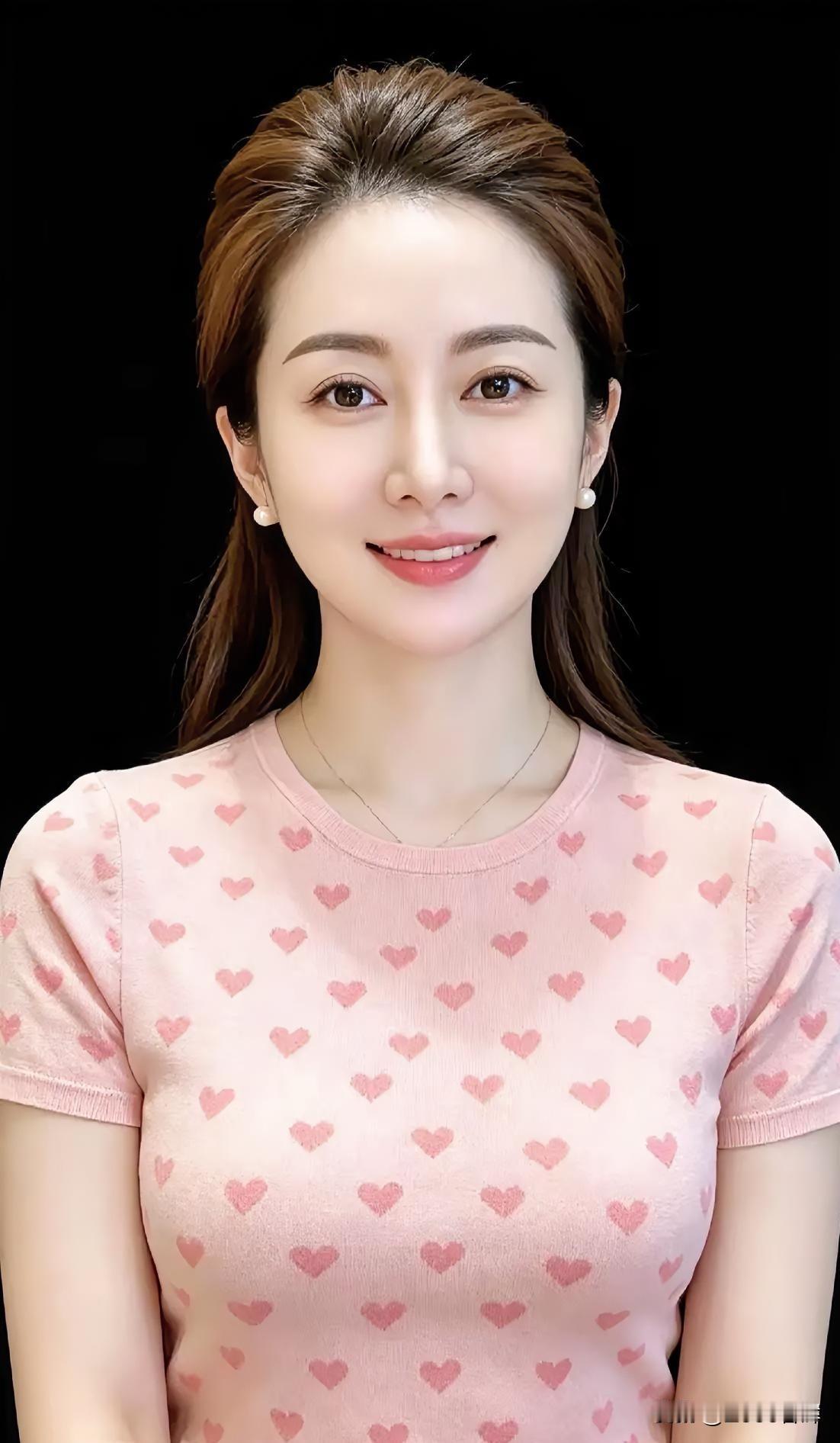 粉衫缀满心纹，柔发轻垂肩侧。笑意漾开眉眼，暖意漫入心扉。珍珠耳畔