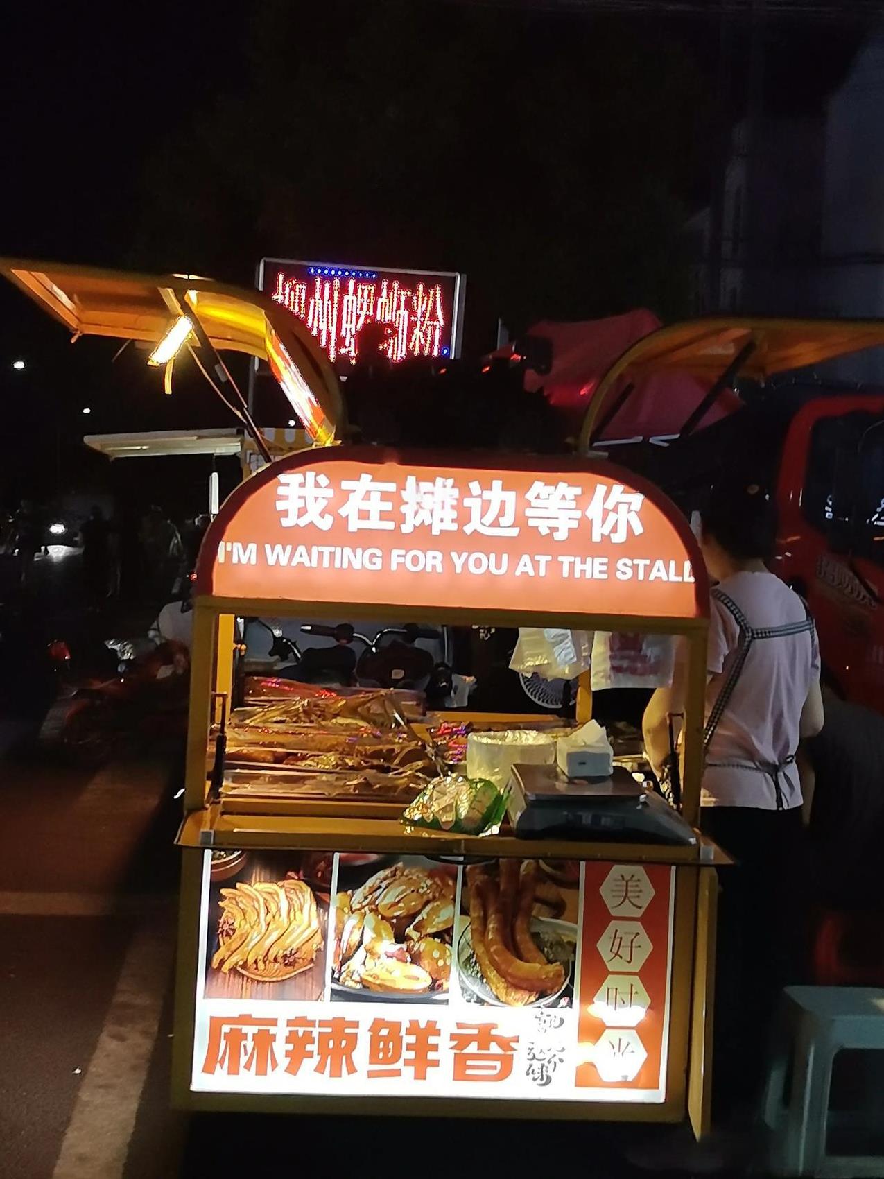夜色里，路边小摊的生意却红红火火。一路过去，各种吃食摊都有，广西螺蛳粉，陕西肉