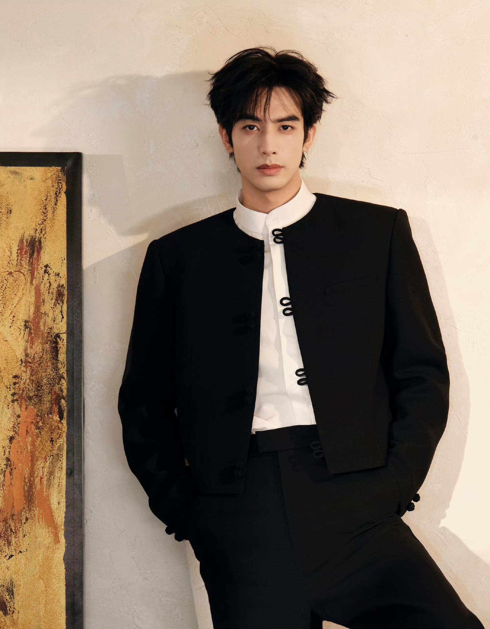 宋威龙今日《骄阳似我》庆功会造型，身着新中式黑色套装亮相，盘扣、白衬衫、红底鞋