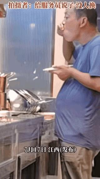 一男子在火锅店的蘸料台子边上拿着一把勺子挨个品尝，吃相让人看着极其闹心，难不成所