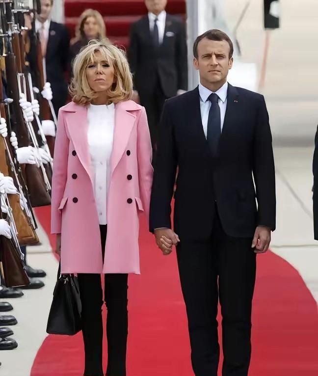 谁敢信这是70多岁的老太太？布丽吉特这粉大衣配紧身裤，脚踩恨天高，站在小25岁