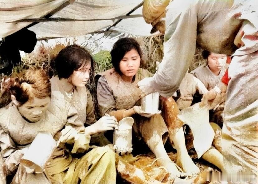 1979年，对越自卫反击战中，一名战士正在给抓获的越军女兵发放罐头。这些女兵十分
