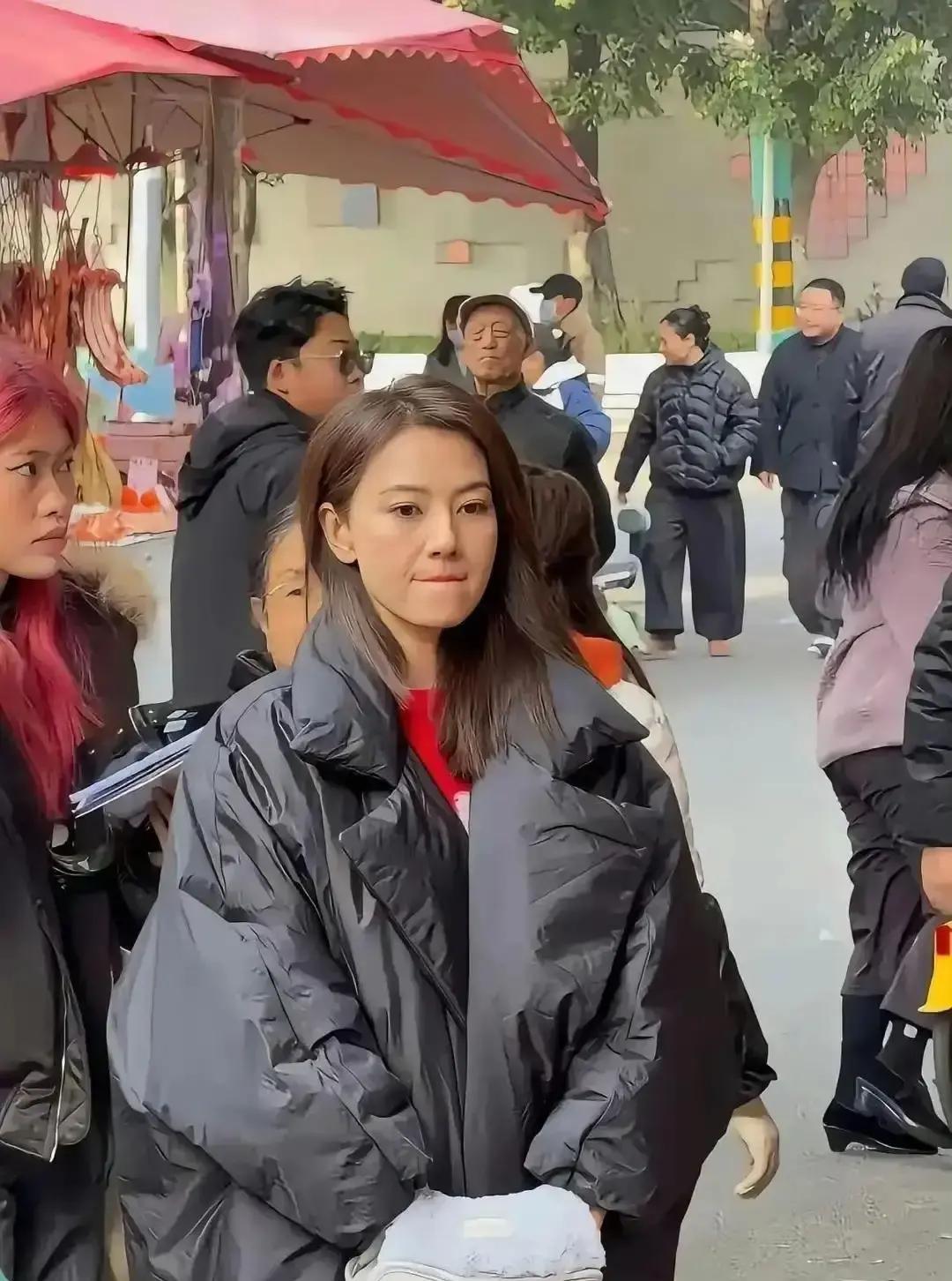 高圆圆素颜在云南县城赶集，穿平价羽绒服排队买红薯，被路人认出拍照。视频里她眼角