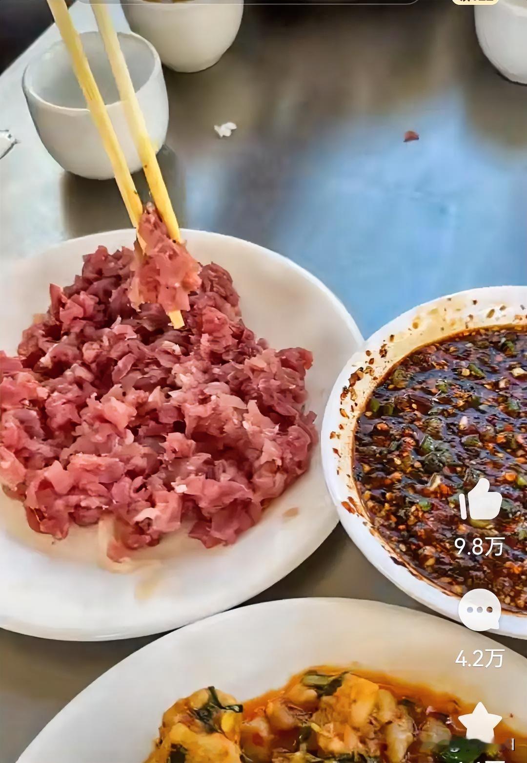 云南吃猪肉那叫一个生猛啊，案板上的生猪肉拿刀割一块下来就往嘴里吃，把猪肉切成丝，