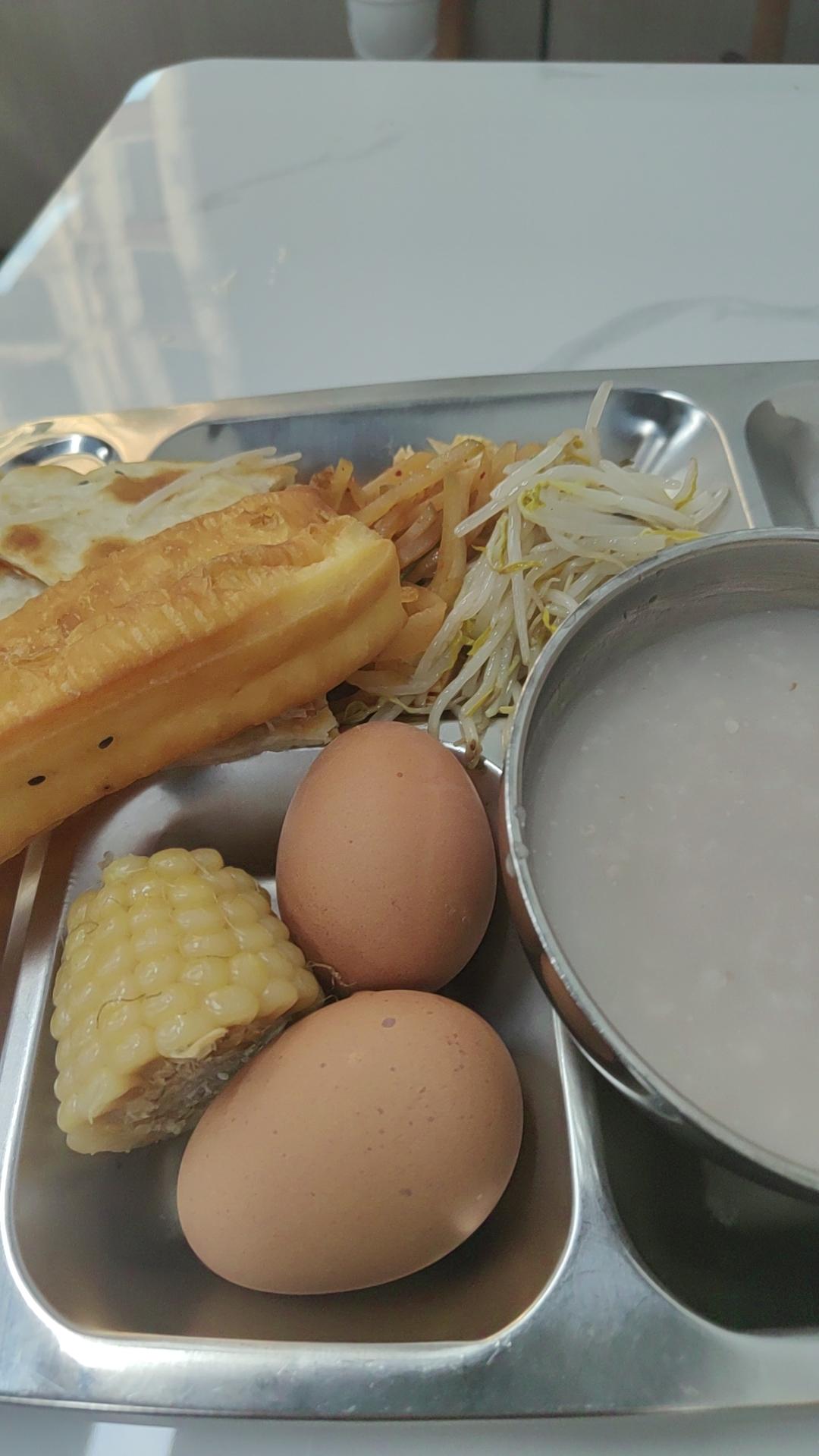 分享我这周有趣的事：这早餐也太实在了吧！俩鸡蛋+玉米+油条+饼，还有粥和小菜，一