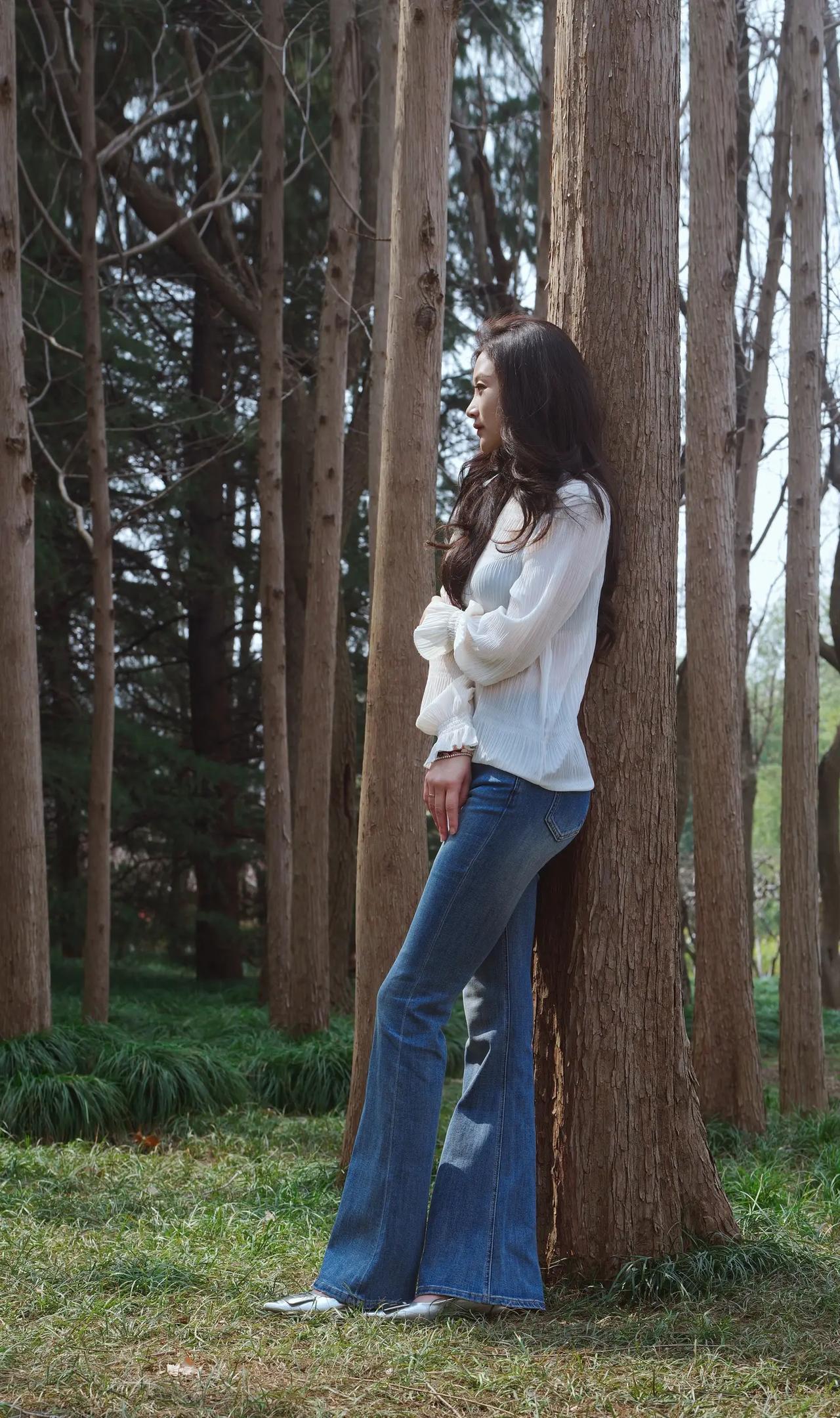 林间倚树思悠长，白衣飘飘意自闲。