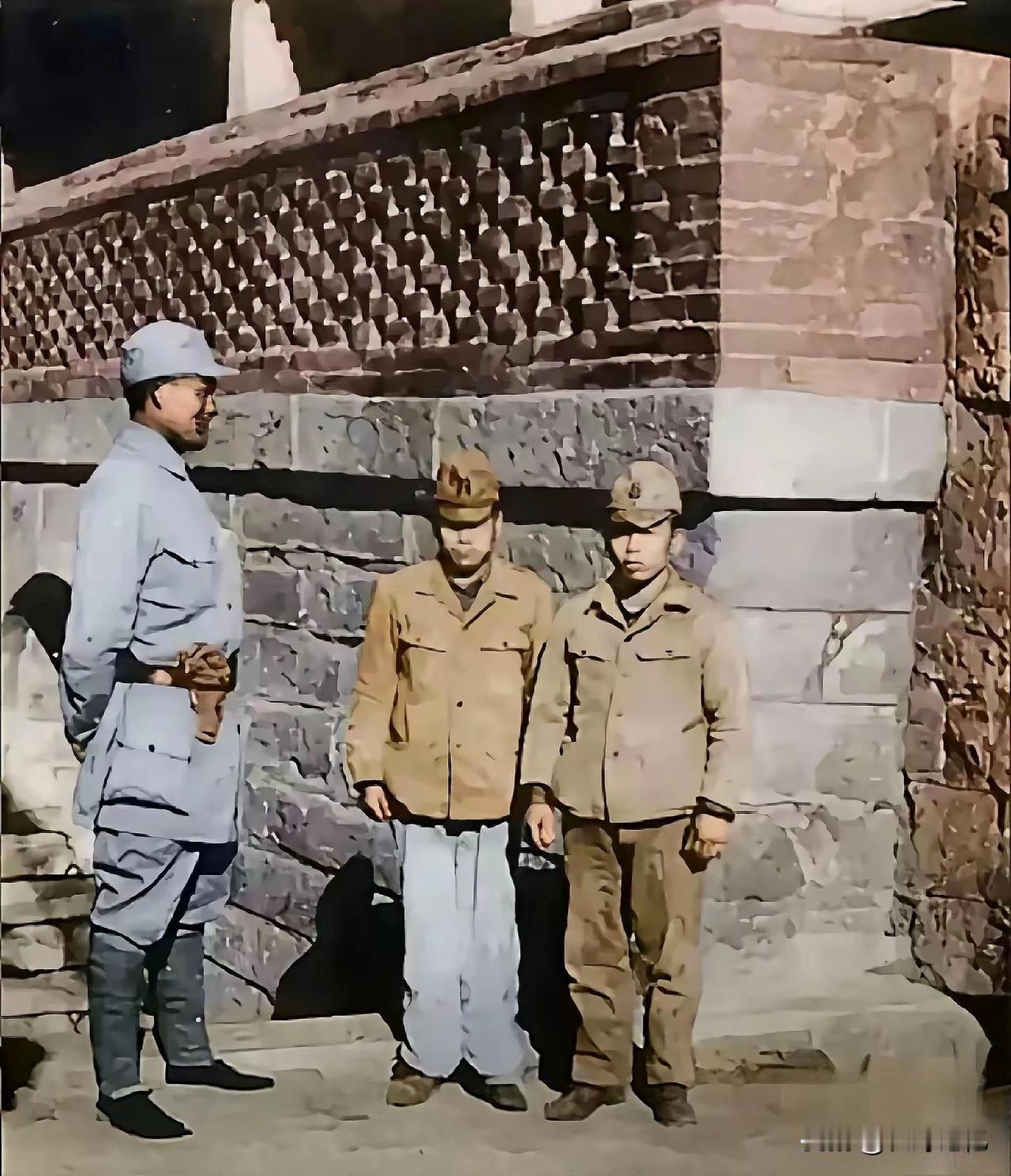 照片中老老实实站在墙边的是抗日战争时期被八路军俘虏的两名日军。当时俗称“小鬼