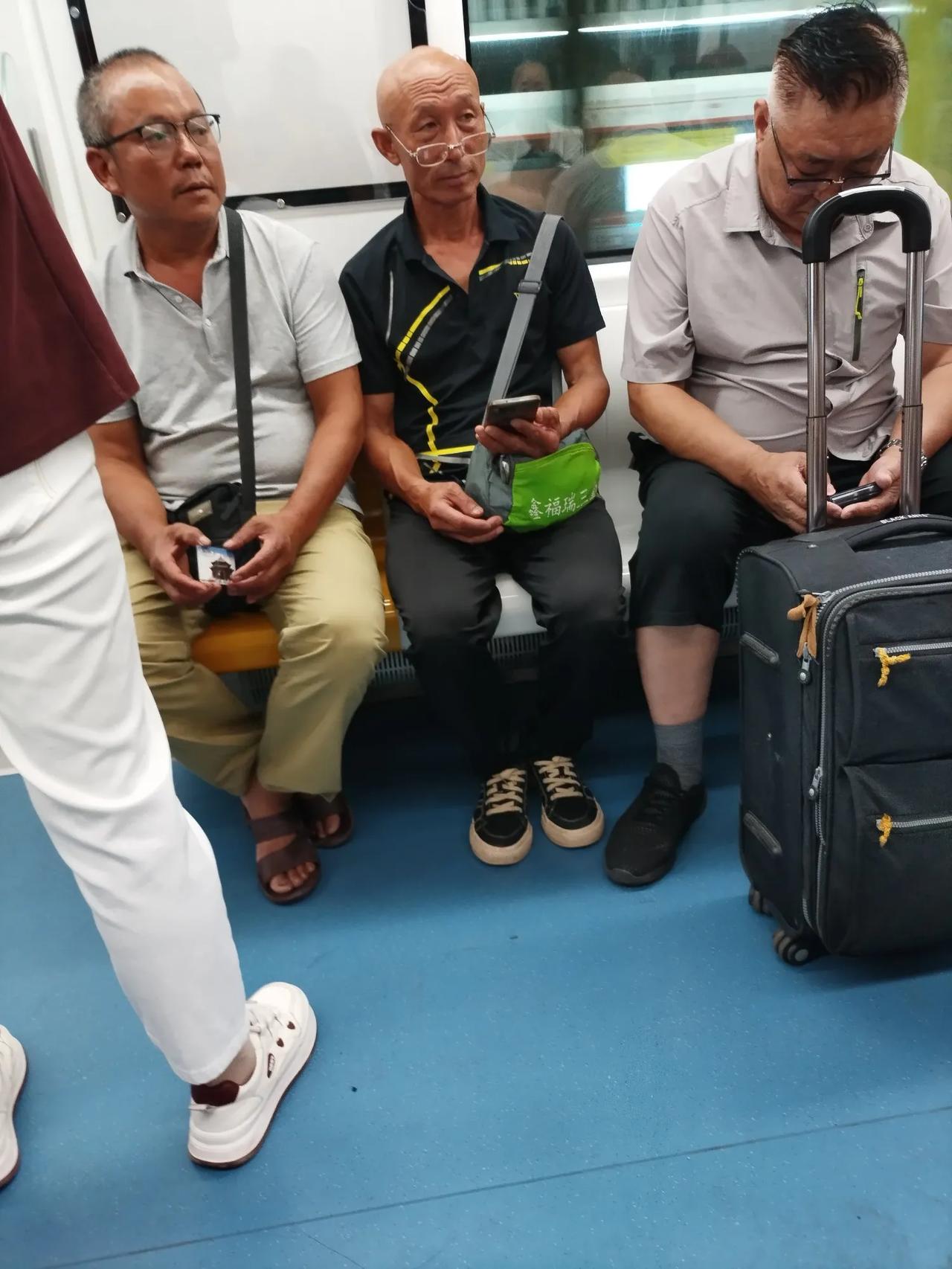地铁对面坐着三位戴眼镜的老者。中间这位就是一个企业退休的工人，退休金在400