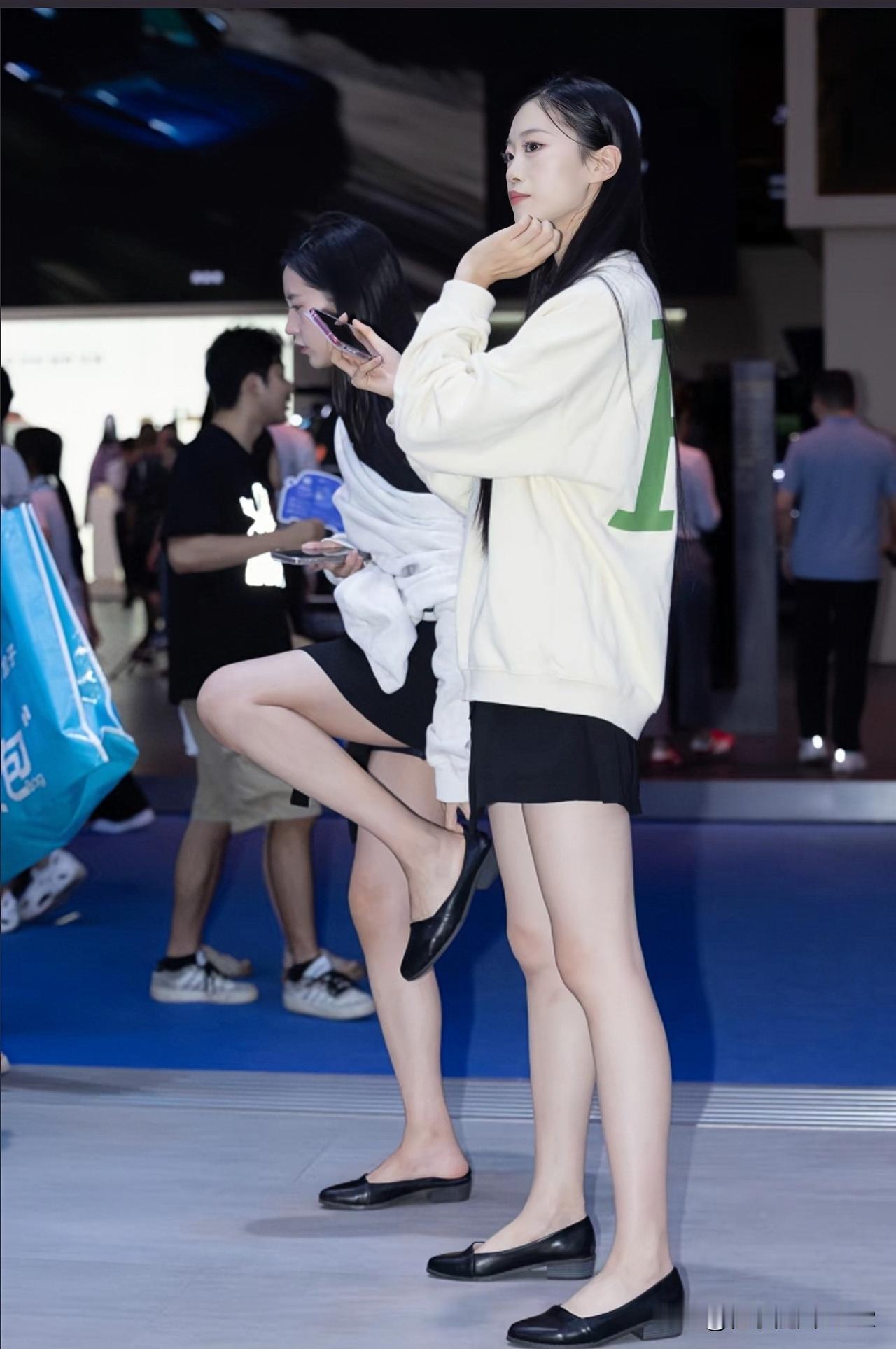 白色卫衣搭配黑色短裙，青春活力，时尚感十足