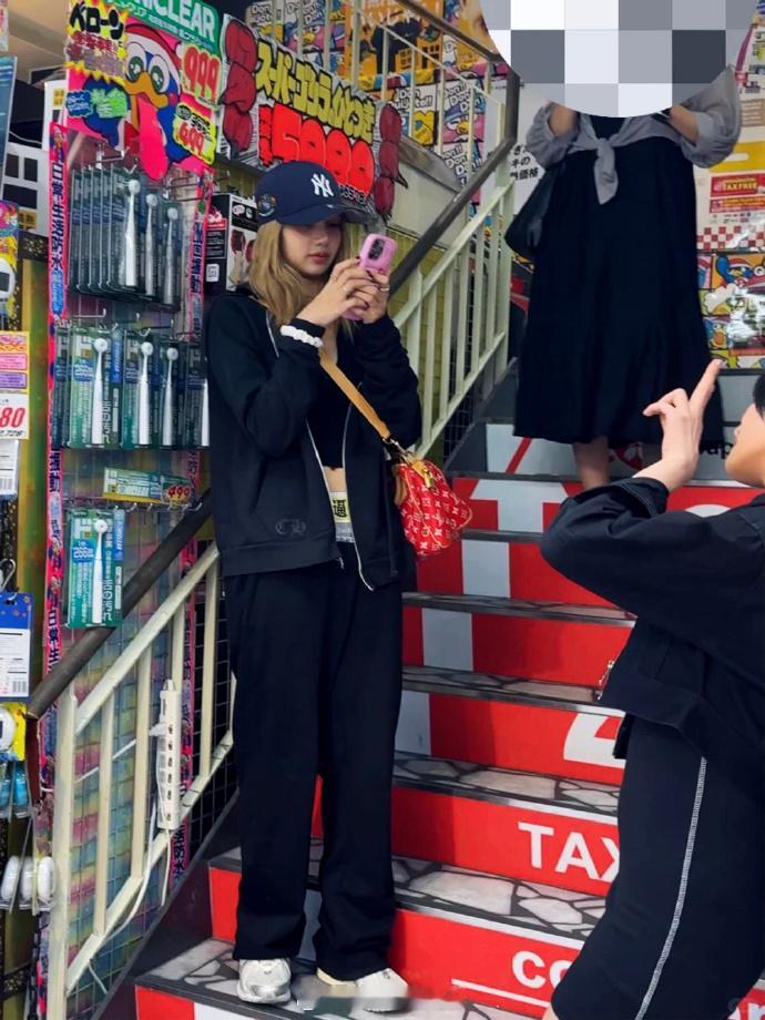 东京街头，Lisa与Minnie同行，Lisa裤子上那串中文，直白道出心