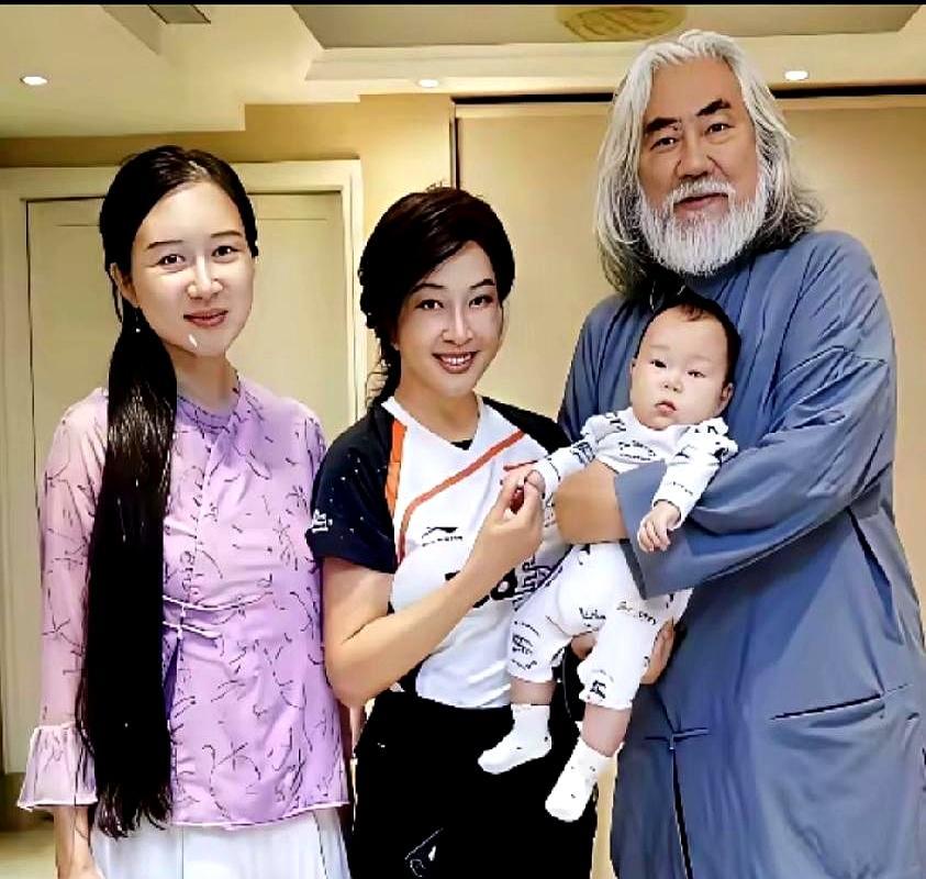 他把3岁女儿递给74岁的刘晓庆，小31岁的妻子，就站在一米开外。张纪中左手