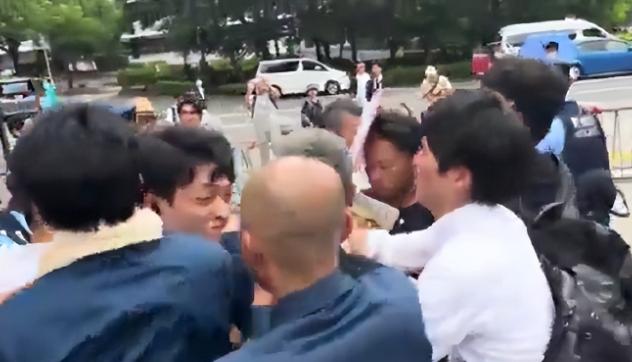 活该！一名精日台湾男子举着"我欢迎日本再次侵华"的牌子，头上还披着乌克兰国旗，像