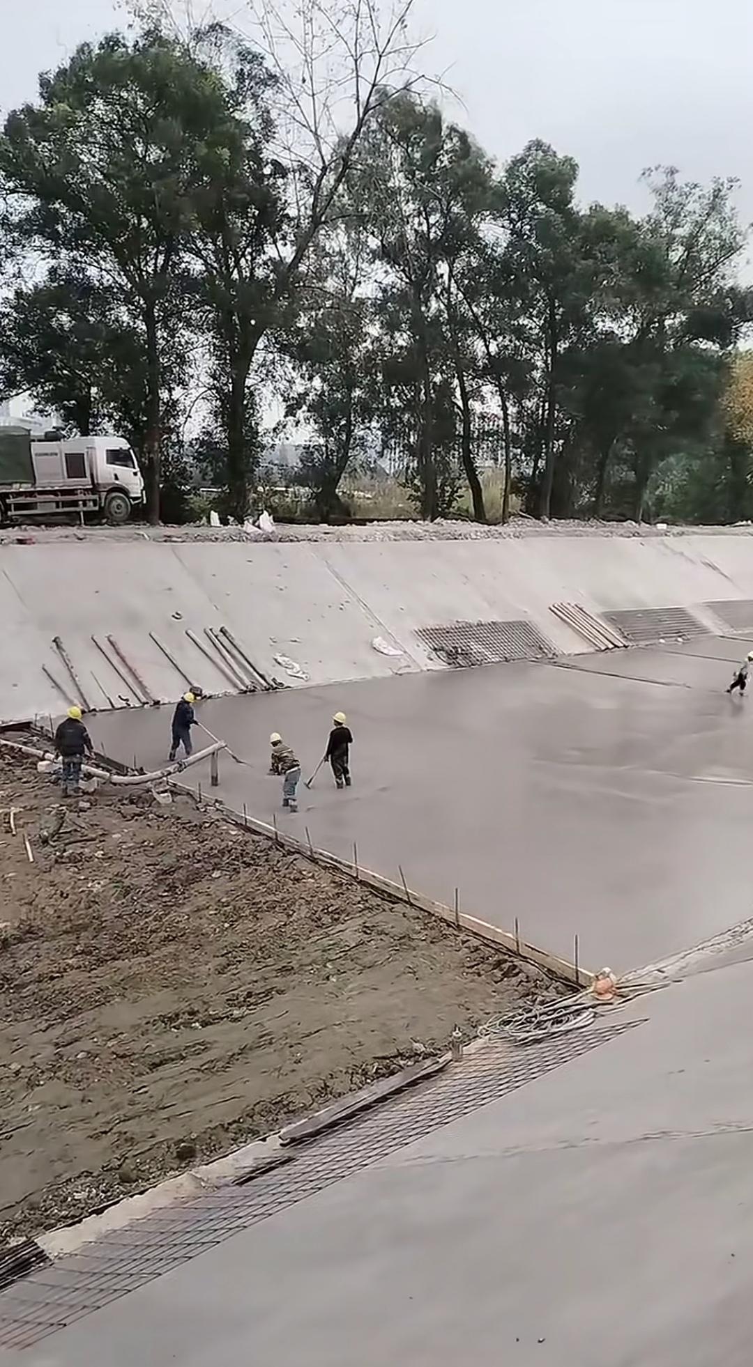 见过用水泥铺设游泳池池底的，也见过铺设拦河坝坝底的，却从未见过铺设河床的。要说铺