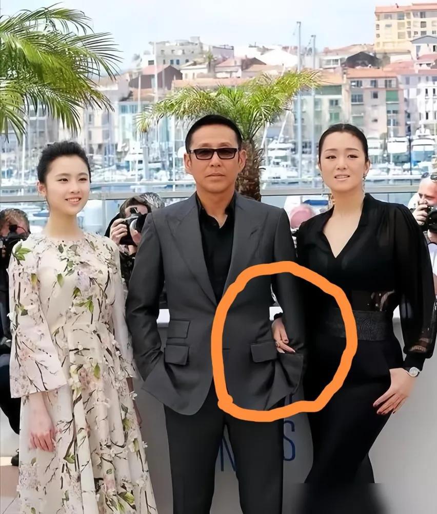 戛纳红毯上，巩俐原本挽着陈道明的手张艺谋一走近，她手松了。就那一秒，媒体镜头全炸了。红毯上人挤人，她