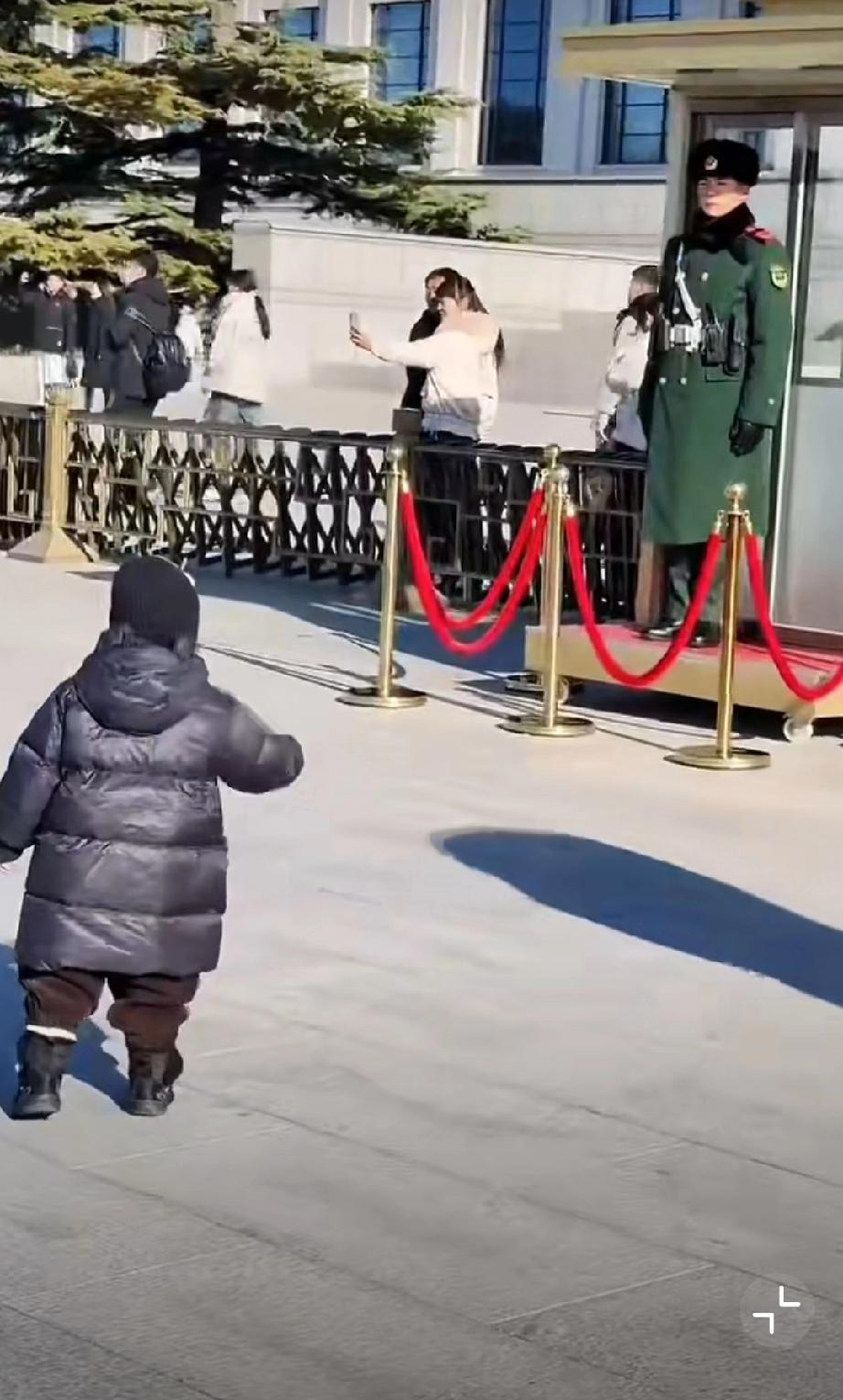 小朋友步履蹒跚向军人敬礼！战士脱了皮手套，用白手套回礼，他们身边一个坐着轮椅的老