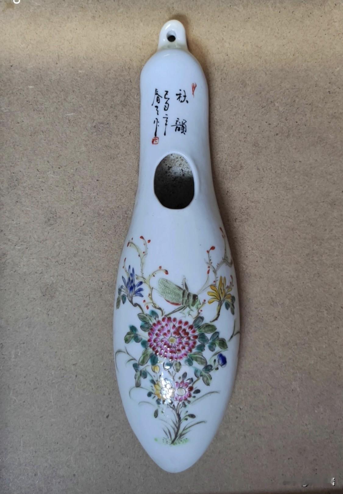 这件瓷质挂件名为“秋韵”粉彩草虫花卉纹瓷挂，属于近现代景德镇文人瓷画风格的装饰性