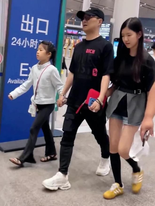 汪峰一家出游回京，携四个子女现身机场。汪峰父爱满满，牵着两个女儿同行。三个女儿各