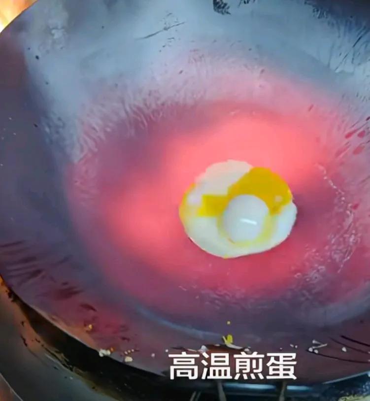 男子把锅烧的通红煎鸡蛋，蛋跟锅分离，油都不需要了，只见男子把鸡蛋打在了通烧的通