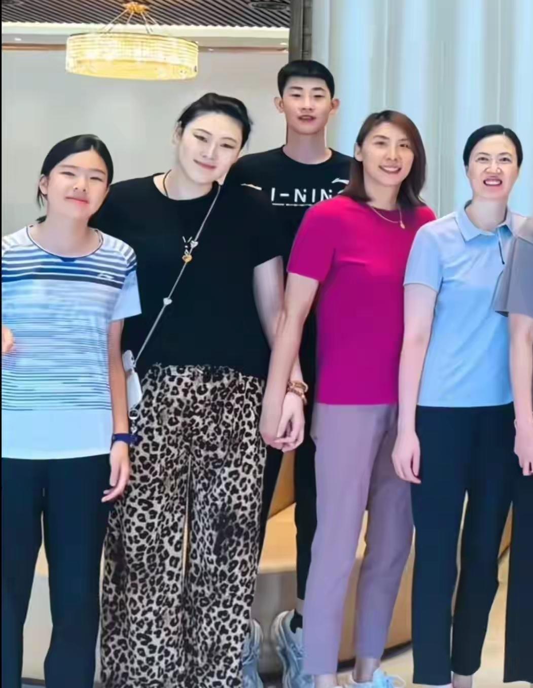 这张合照，我只认出了穿着浅蓝色上衣、笑容灿烂的女排名将周苏红与皮肤白皙、身着豹纹