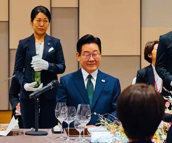 李在明身旁工作人员眼神是在暗示什么意思呢？手里拿的是酒吗？这是通过眼神在沟通