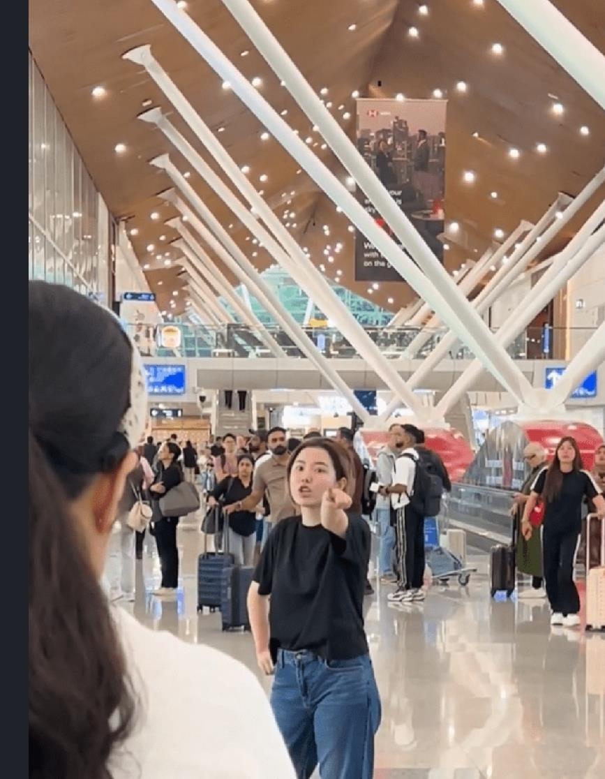 吉隆坡机场，一个中国女孩赤脚站在大厅中央，举着手臂高声叫嚷，让新加坡、日本、马来