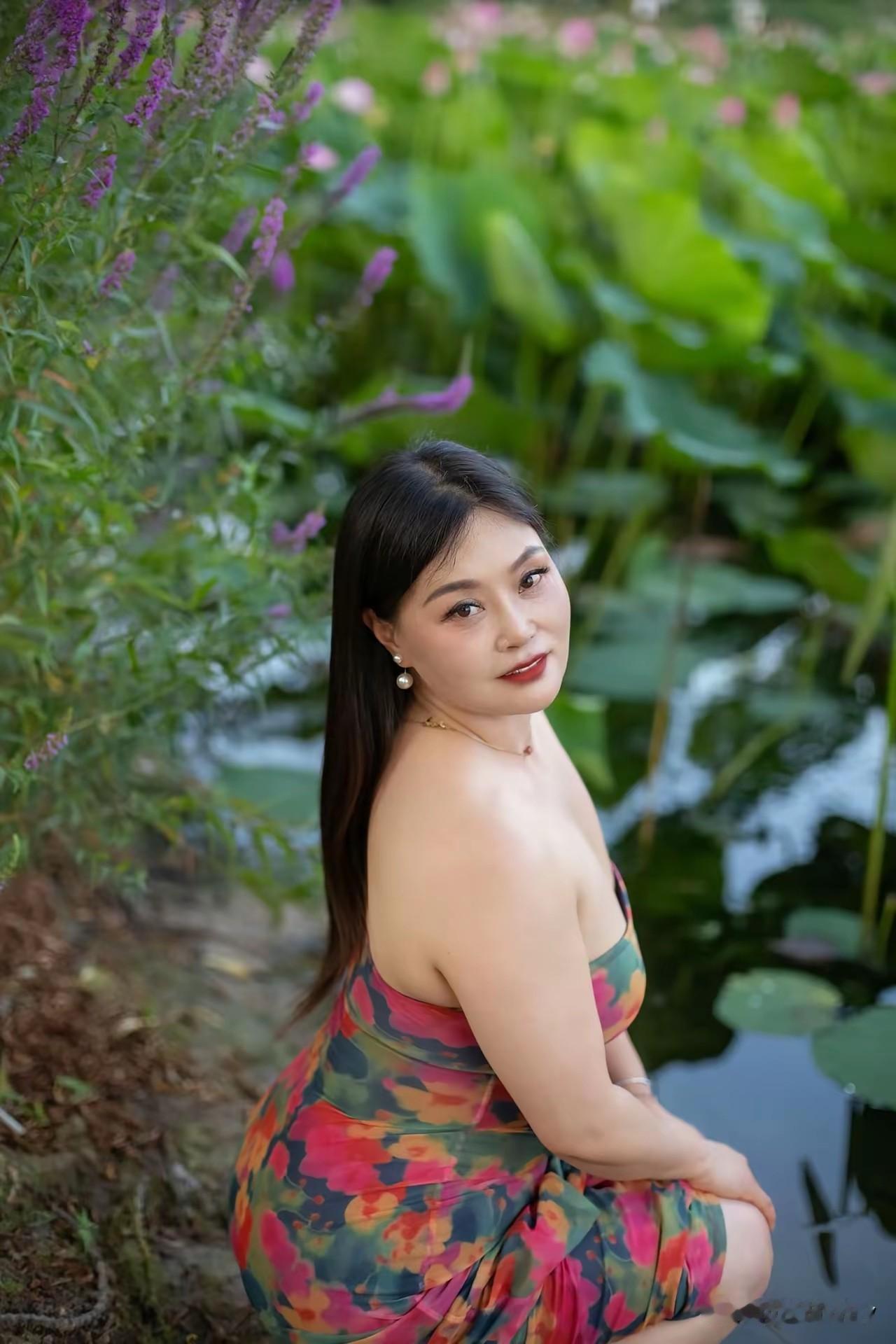 夏日荷塘中的少女，裙摆随风飘动，宛如一幅动人的画卷。