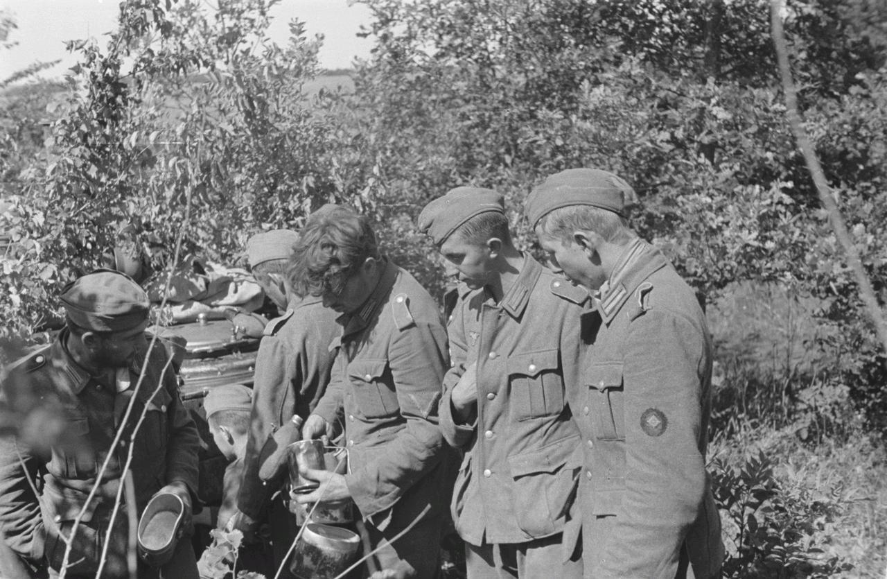 1943年，东线，库尔斯克州。德军第167步兵师的士兵们聚集在野战炊事车旁，准备