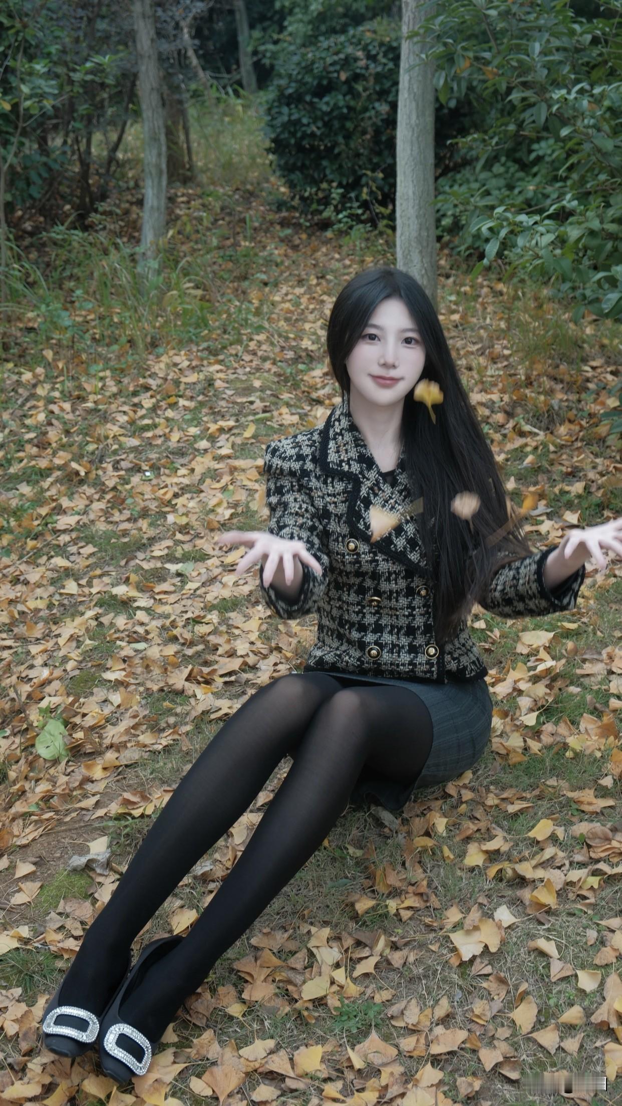 如何穿搭显得淑女一点秋日午后，公园长椅上，优雅黑裙与格纹外套相得益彰，手机轻触，