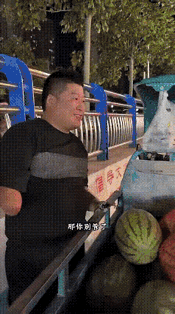 街头的残疾小伙守着满满一车西瓜叫卖，一名路过的男子停下来尝了一块，没扫码付钱，反