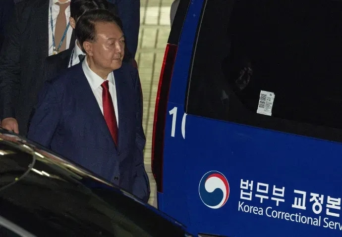 在特检组强大压力的审问下，尹锡悦终于低头认罪。当他被押上警车时，整个人显得异常低