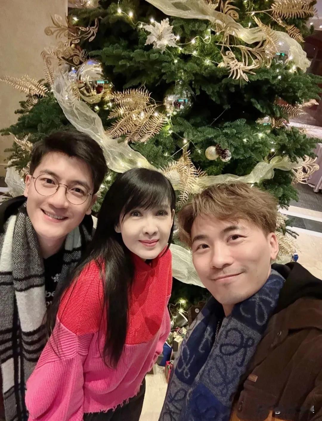 港星女神周慧敏，和朋友一起过圣诞节。58岁的她，穿着一件玫红色毛衣配黑色长裙，