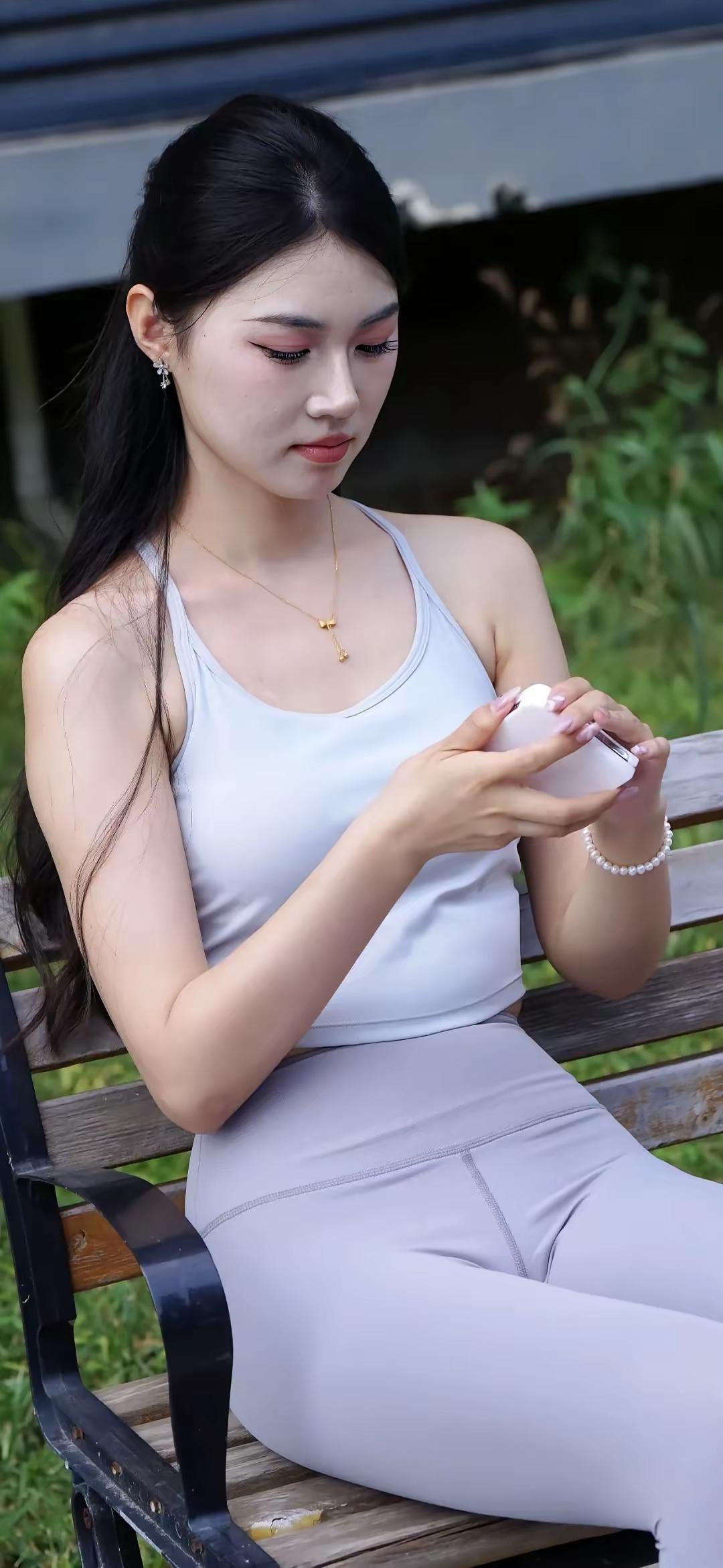 一位美女在公园长椅上涂指甲油。梨形身材女生怎样穿衣搭配瑜伽裤和鲨鱼裤的区别,你