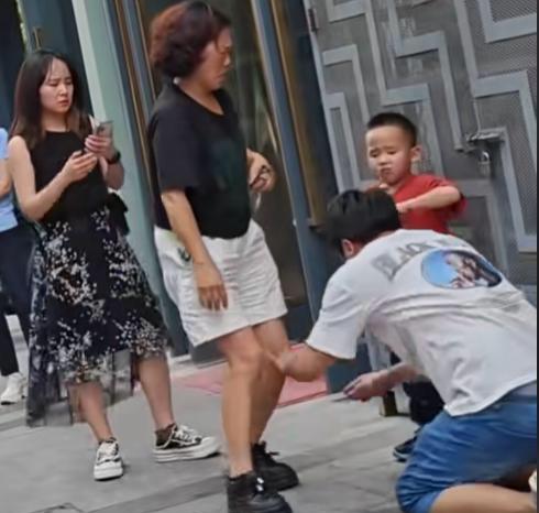 南京街头，一男子跪在水泥地上，向劈腿老婆连磕三个响头，哭喊：“我一天打两份工，从