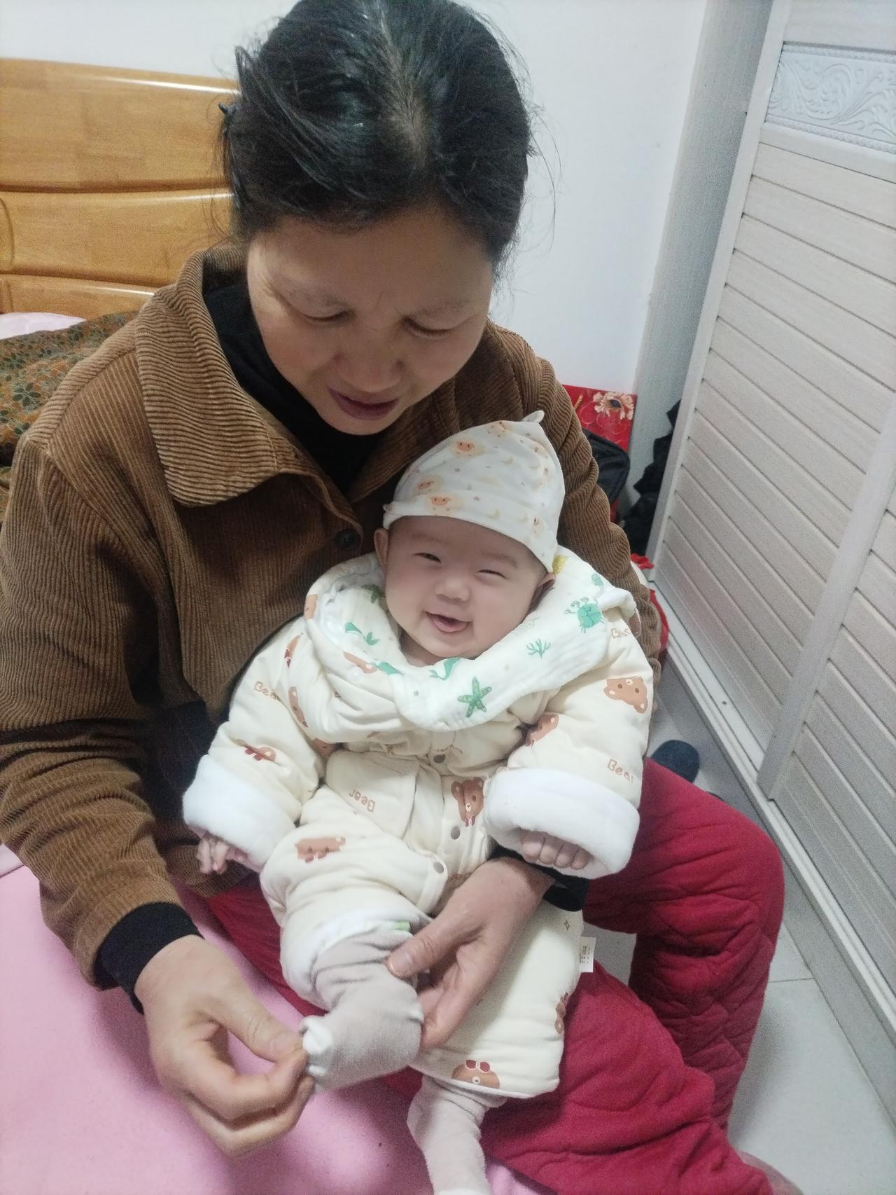 昨天晚上无意间拍到外婆给宝宝穿袜子，宝宝看到妈妈来了，开心得乐了！于是我赶紧用手