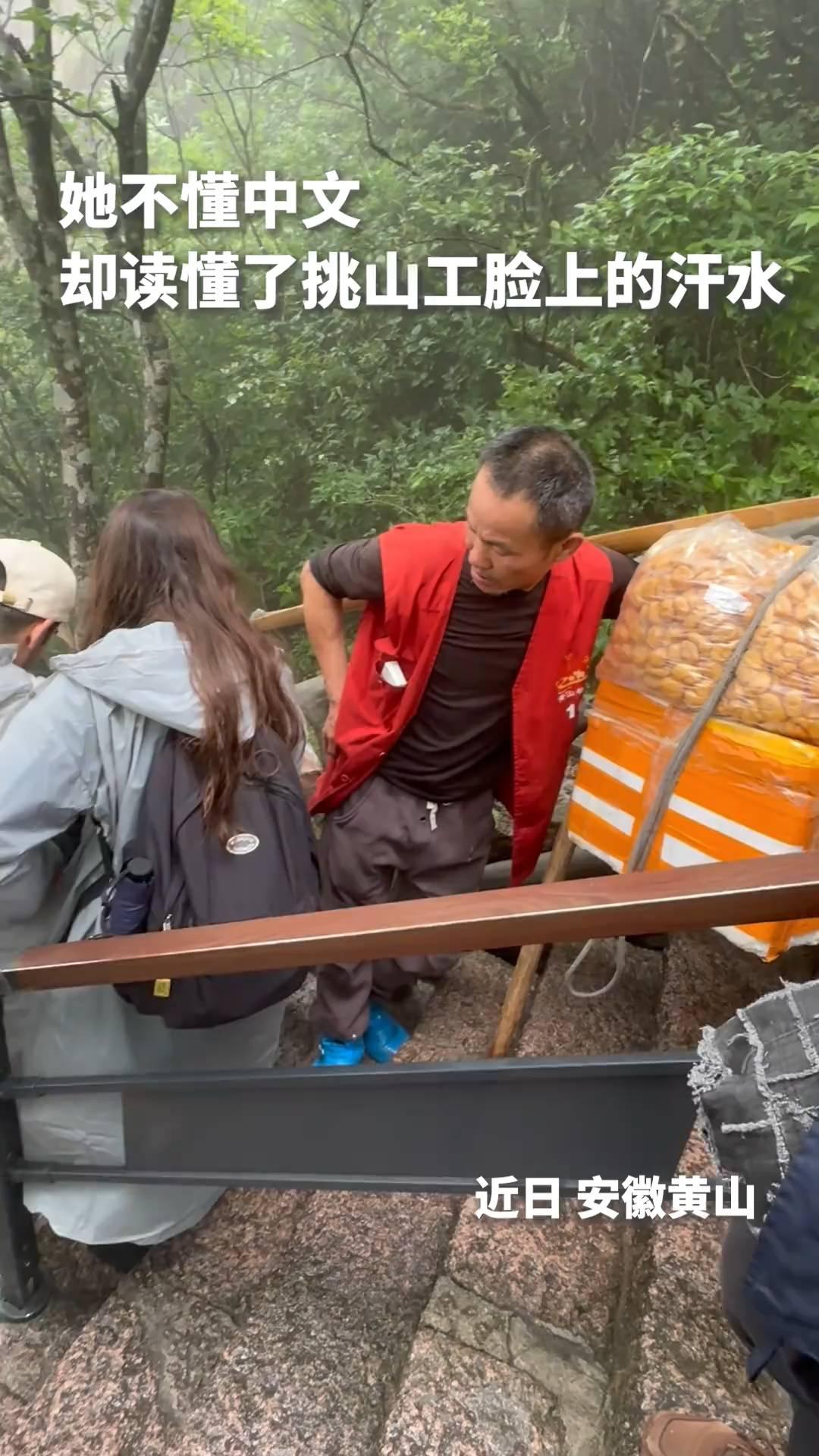 她不懂中文，却读懂了挑山工脸上的汗水。近日安徽黄山。网友：善良与友爱不分国界！