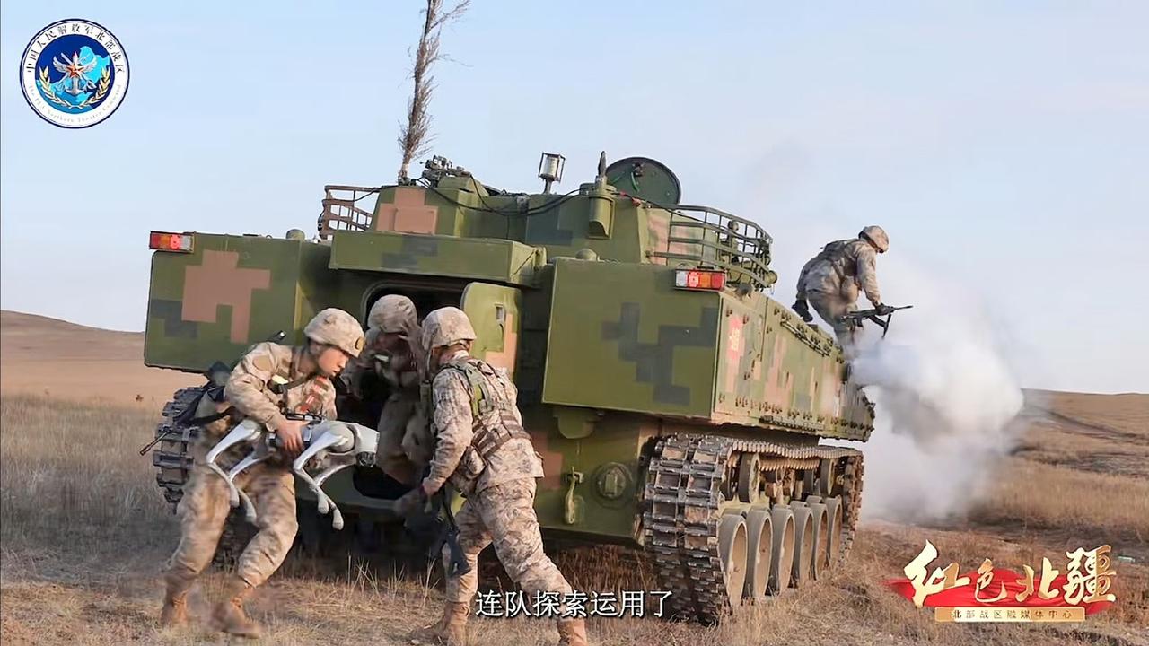 我军步战车载员抱着"狗子"(机器狗)下车作战​。这些四足机器人可搭载自动步枪