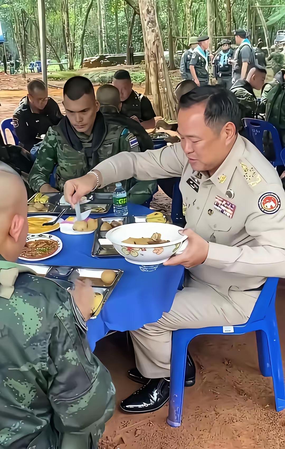 泰国总理到前线慰问战士与战士们共同进餐，总理给战士们夹莱，卤蛋舀起来分别放在战士