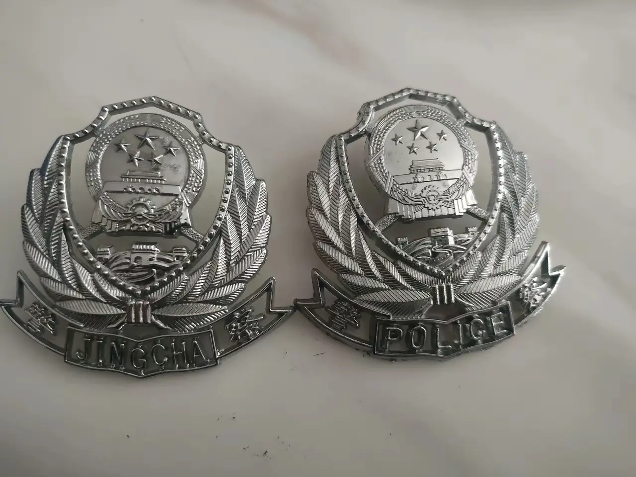 图片中的两个警察帽徽，有什么不同之处？