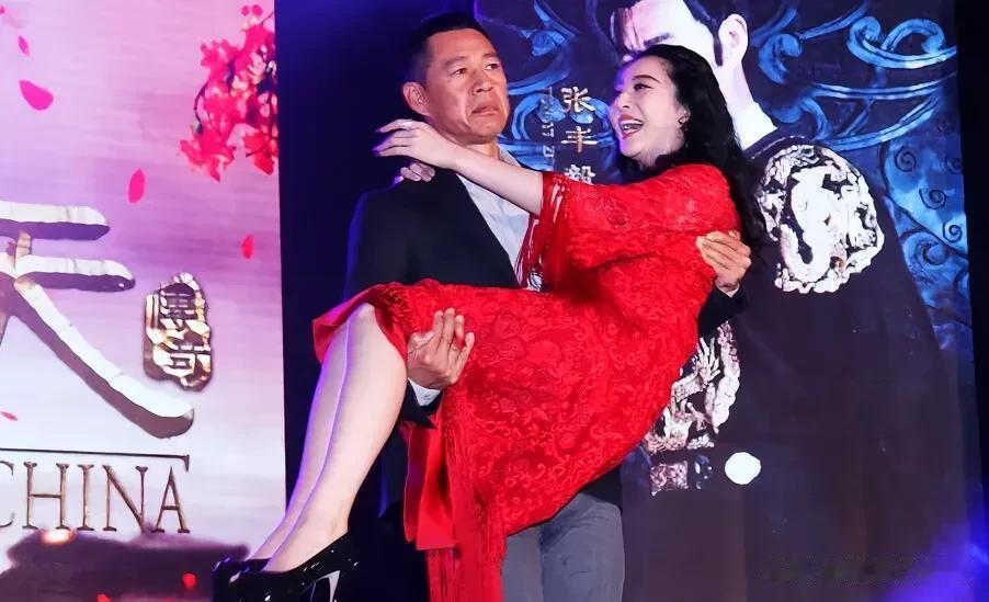 以前在某次活动上，张丰毅公主抱冰冰的情景。照片中，女的笑得很开心，男的脸上毫无
