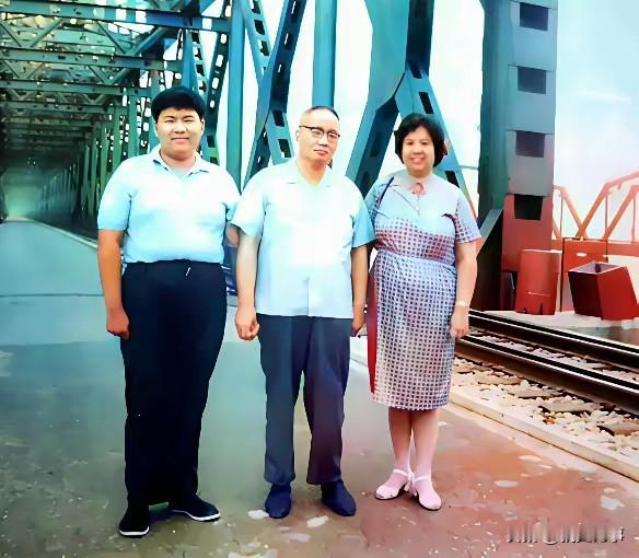 90年代，鸭绿江大桥上，毛岸青携夫人邵华与孩子伫立，隔江遥望兄长长眠之地。镜头下