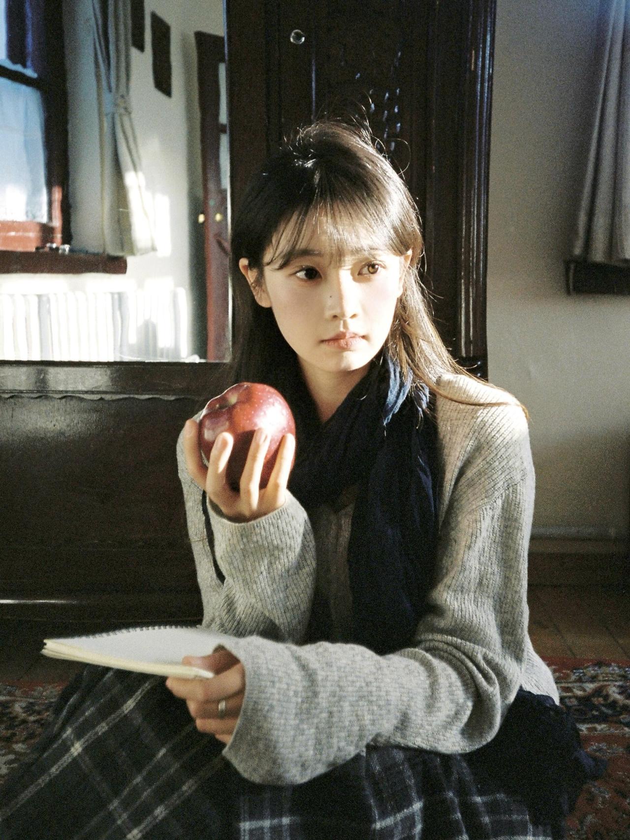 这张照片以蹲姿构图展现人物的松弛状态，复古地毯的繁复花纹与深色木门的雕刻细节，构