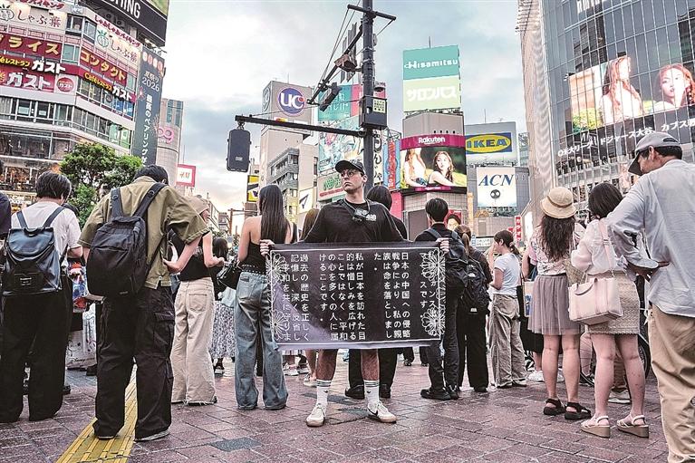 看哭了！在东京街头举南京大屠杀标语遭日本人围攻，两个年轻人没有低头!2026